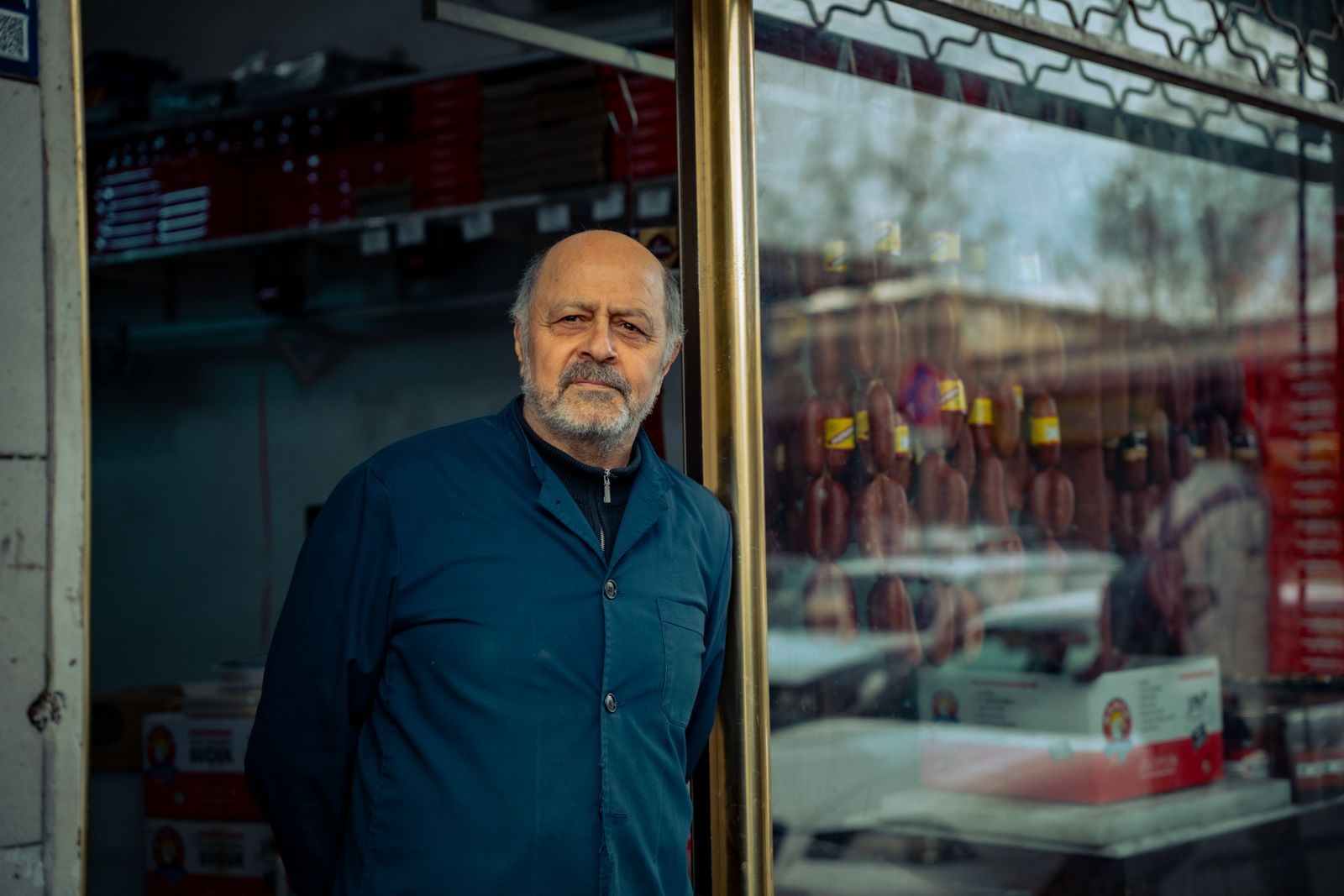 A local shop owner standing in the doorway of his business.
