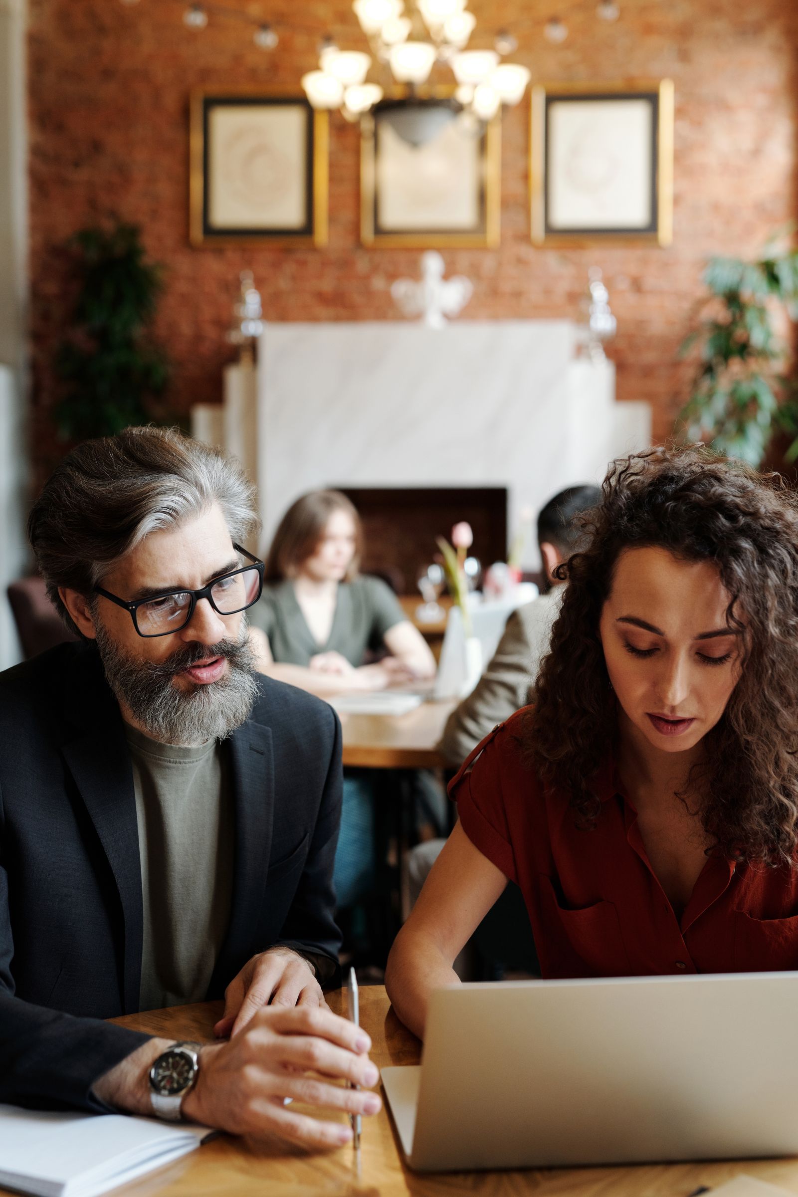 Two professionals calmly reviewing information together at a restaurant table.